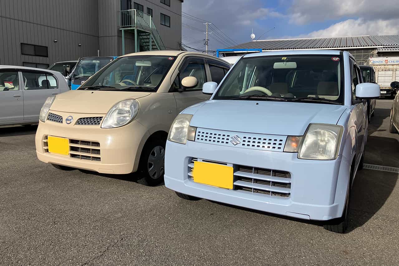 クリーム色と水色の車が２台並んでいる様子